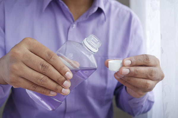 person holding white plastic bottle